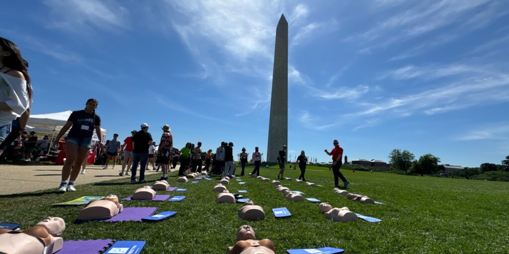CPR manikins lying in the grass with the Washington Monument in the background